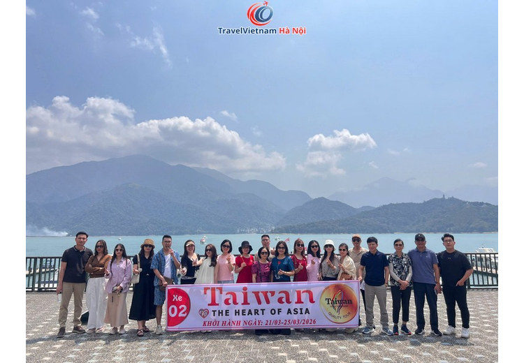 Đoàn khách TravelVietnam Hà Nội chụp ảnh bên bến thuyền Hồ Nhật Nguyệt, phía sau là mặt hồ và núi