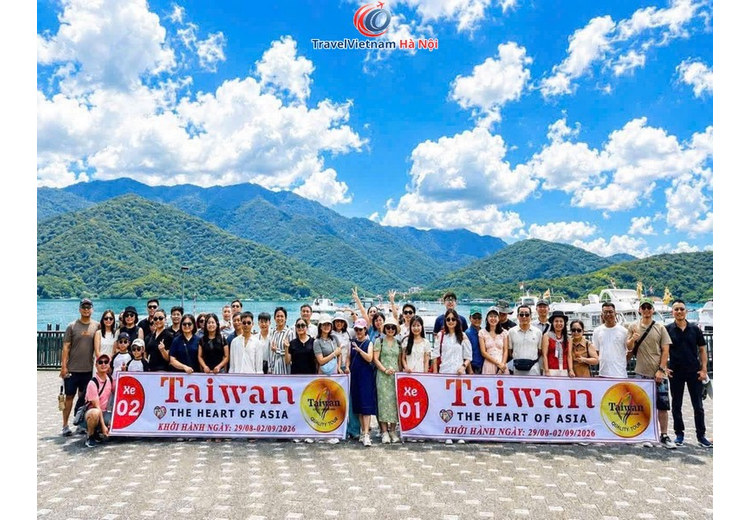 Đoàn khách TravelVietnam Hà Nội chụp ảnh bên Hồ Nhật Nguyệt với núi và mây phía sau