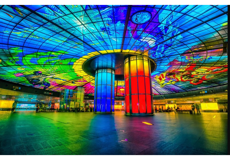 Hai cột kính màu đỏ và xanh ở trung tâm sảnh ga Formosa Boulevard dưới mái vòm