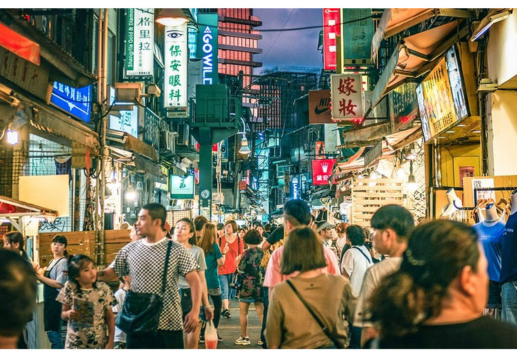 Phố chợ đêm Sĩ Lâm đông người với biển hiệu sáng đèn